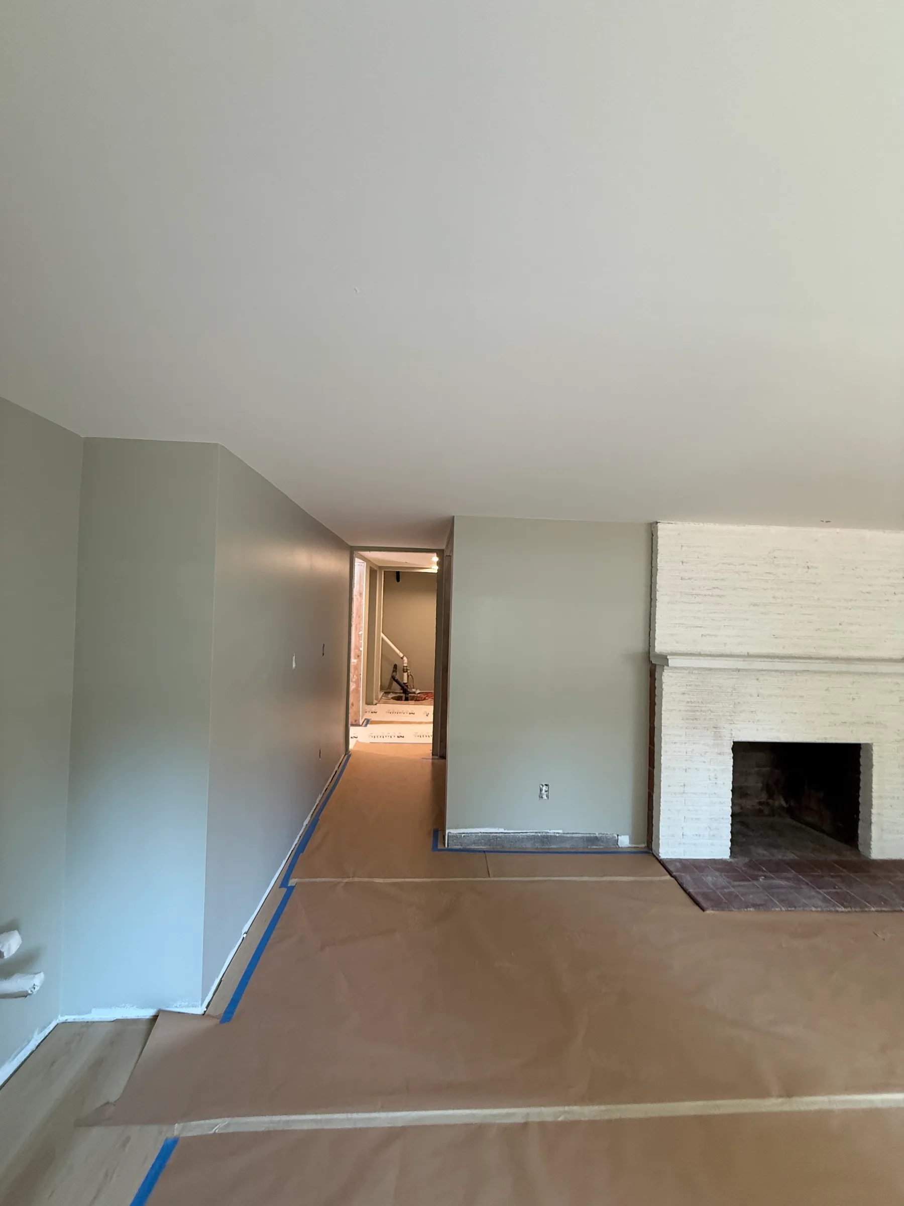 Painted basement living area with floor protection in place