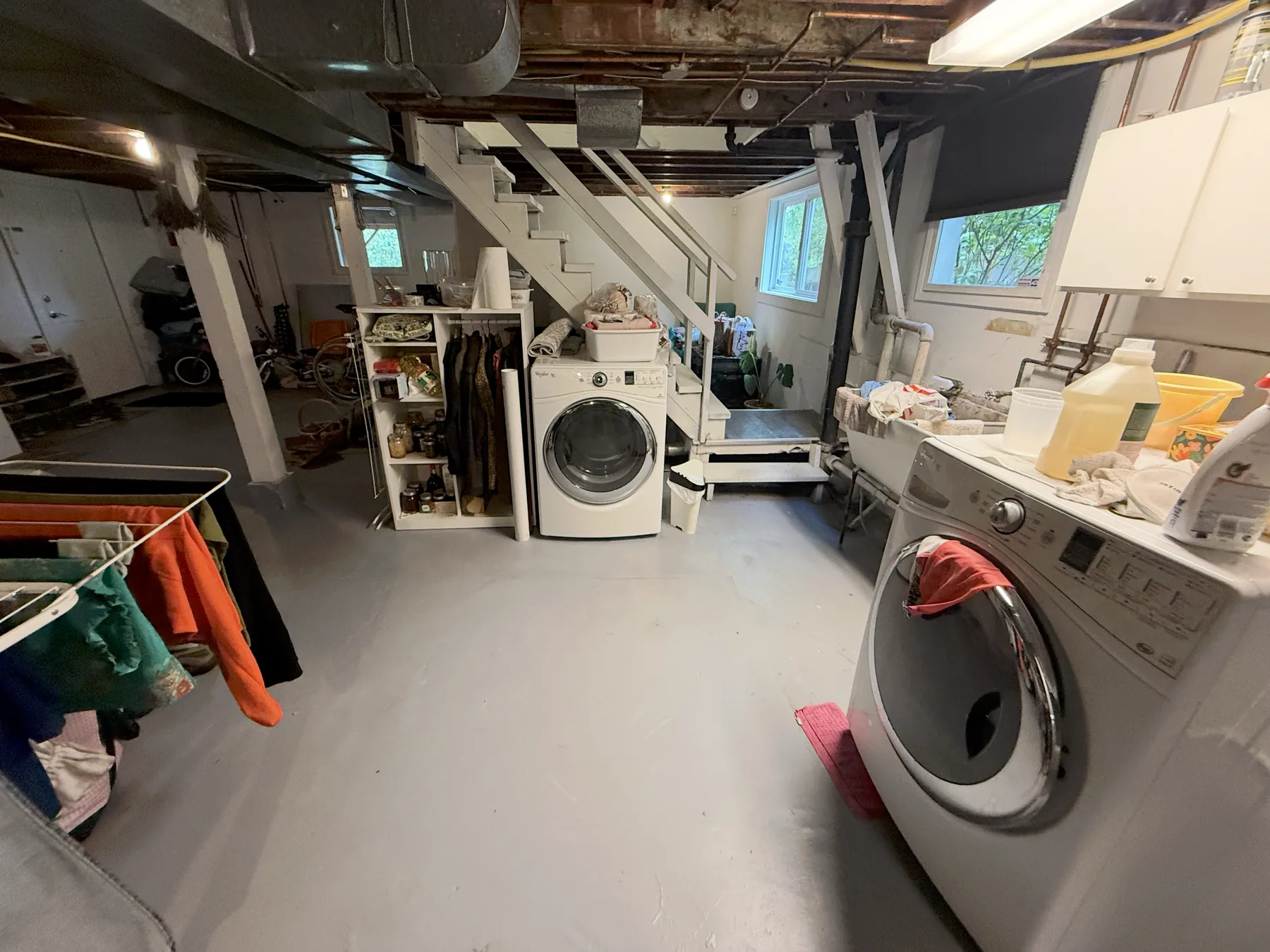 Original basement laundry area and concrete floor before construction