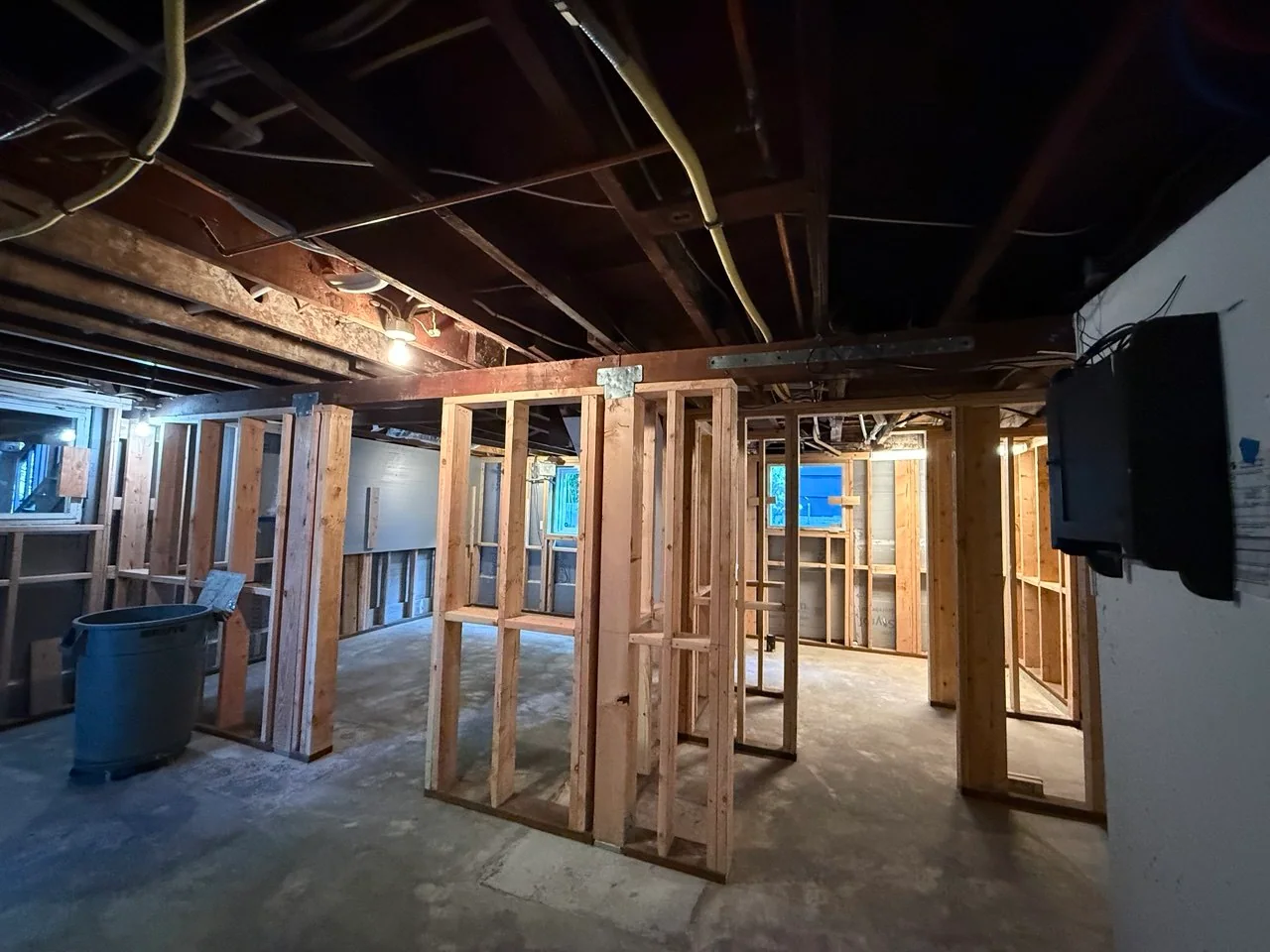 Completed interior partition layout across the basement with open ceiling utilities above