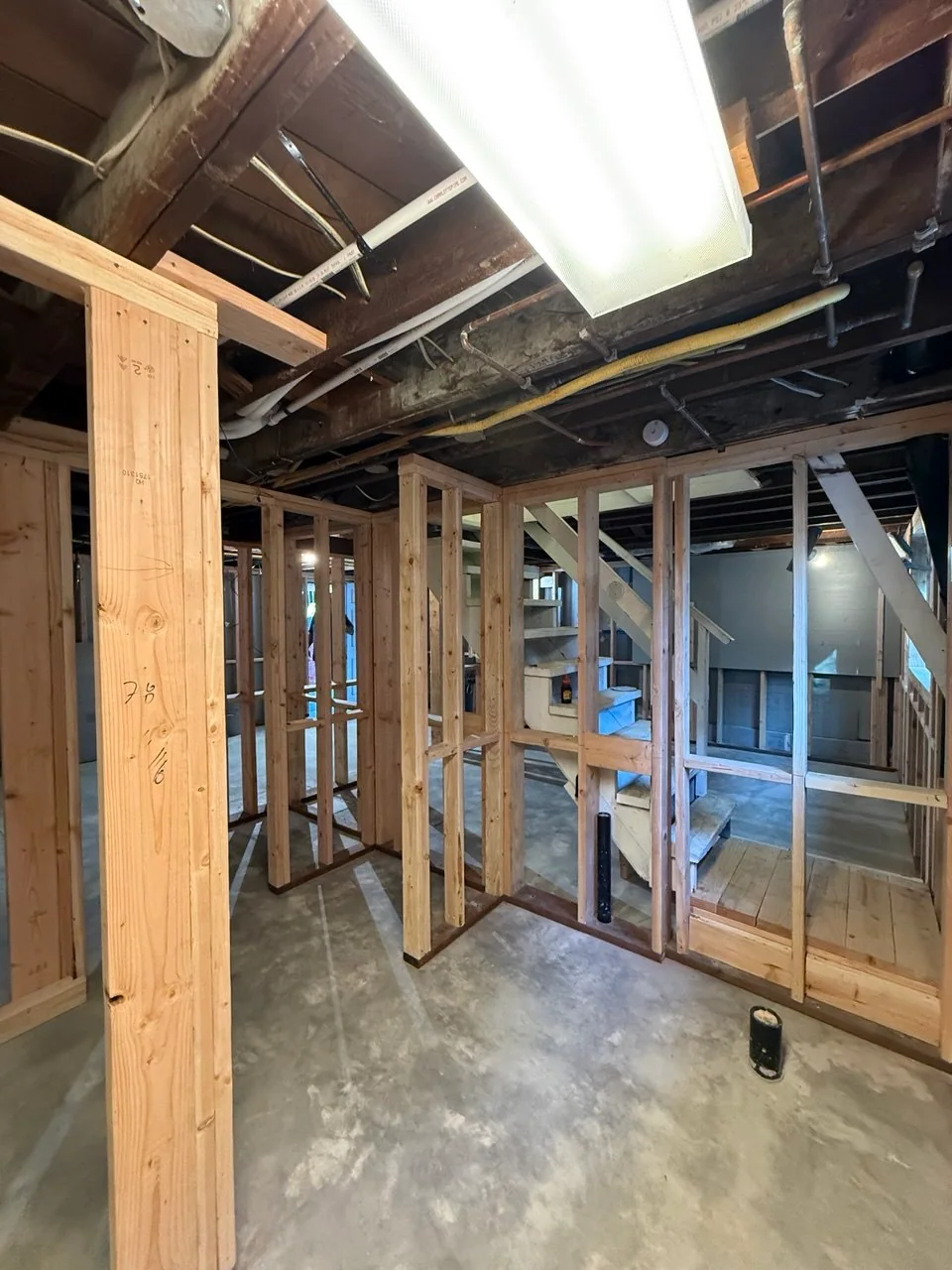 Completed partitions with framed openings, existing stair and plumbing stubs visible