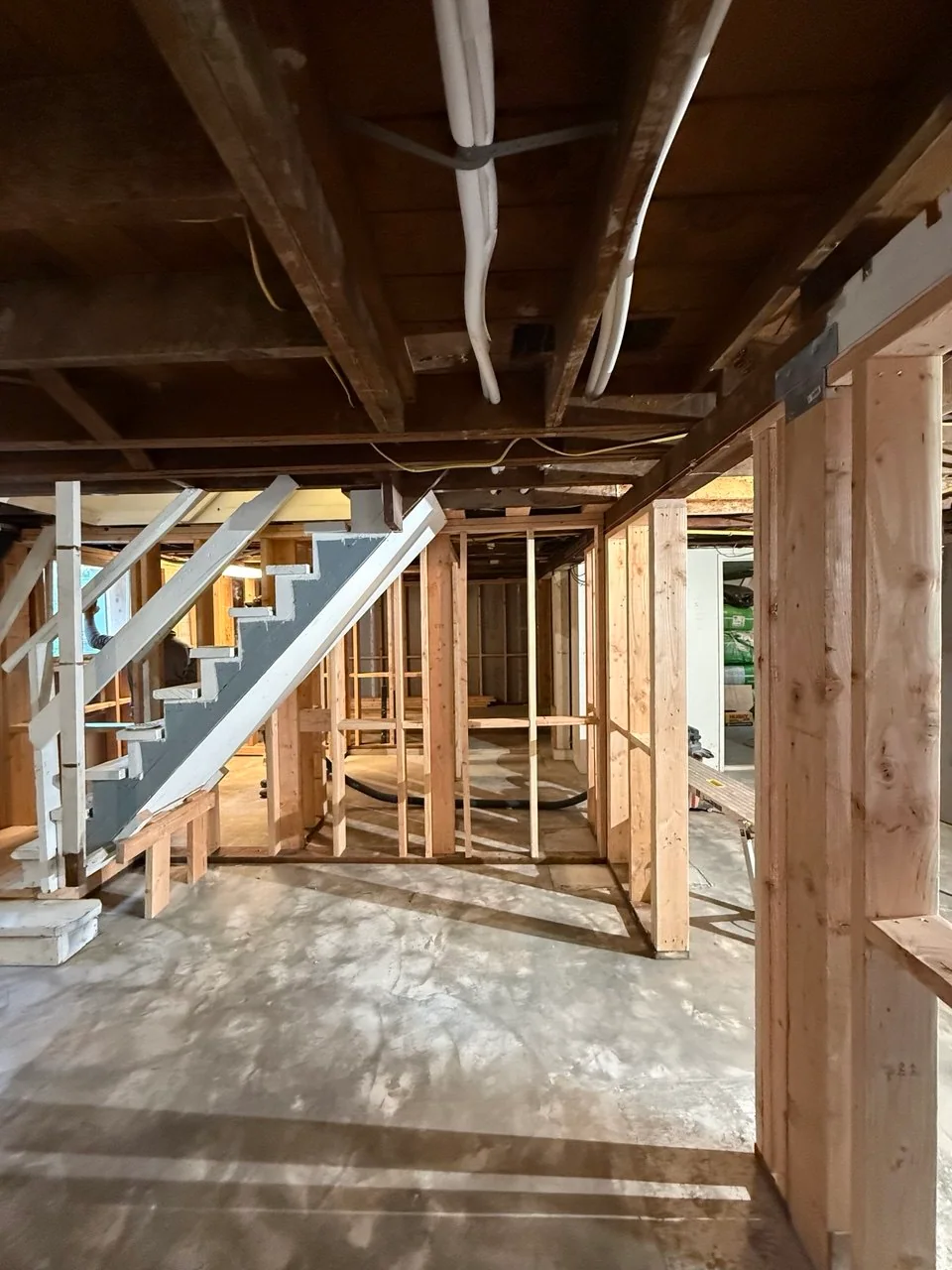 Completed partition framing viewed toward the existing basement stair