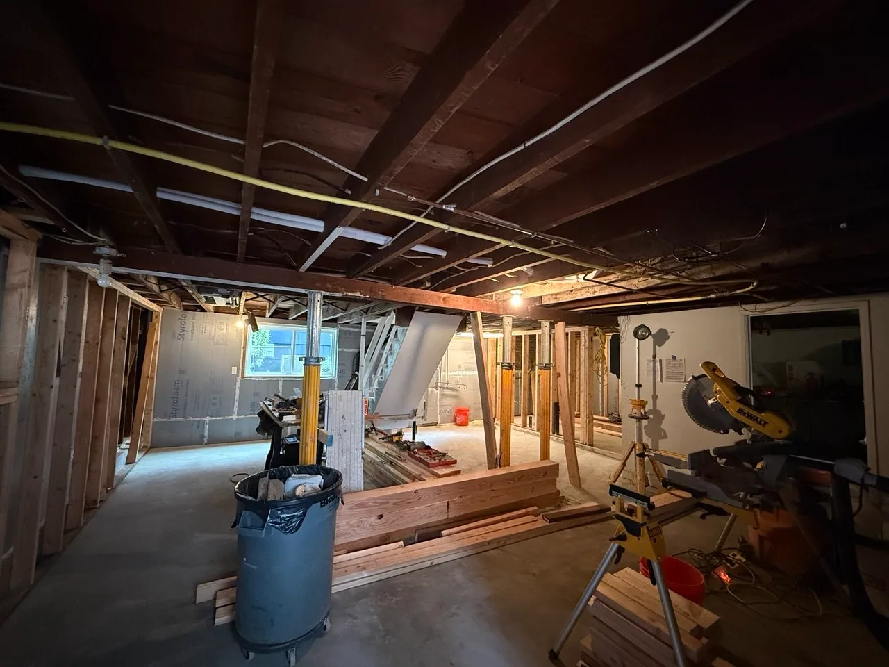 Active framing area with new partition walls, staged lumber and temporary support posts
