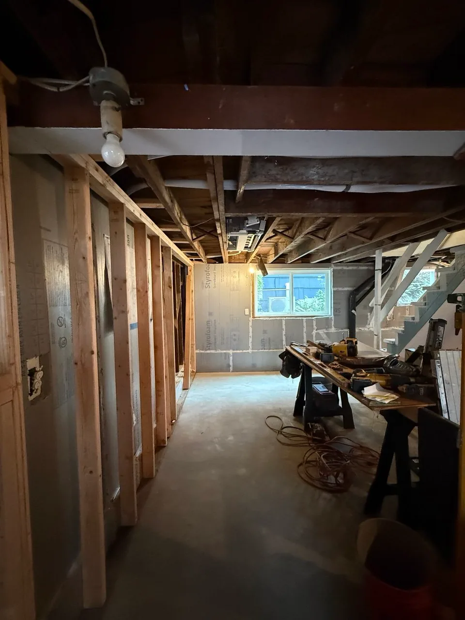 Basement stair area with rigid-foam perimeter insulation and new wood framing