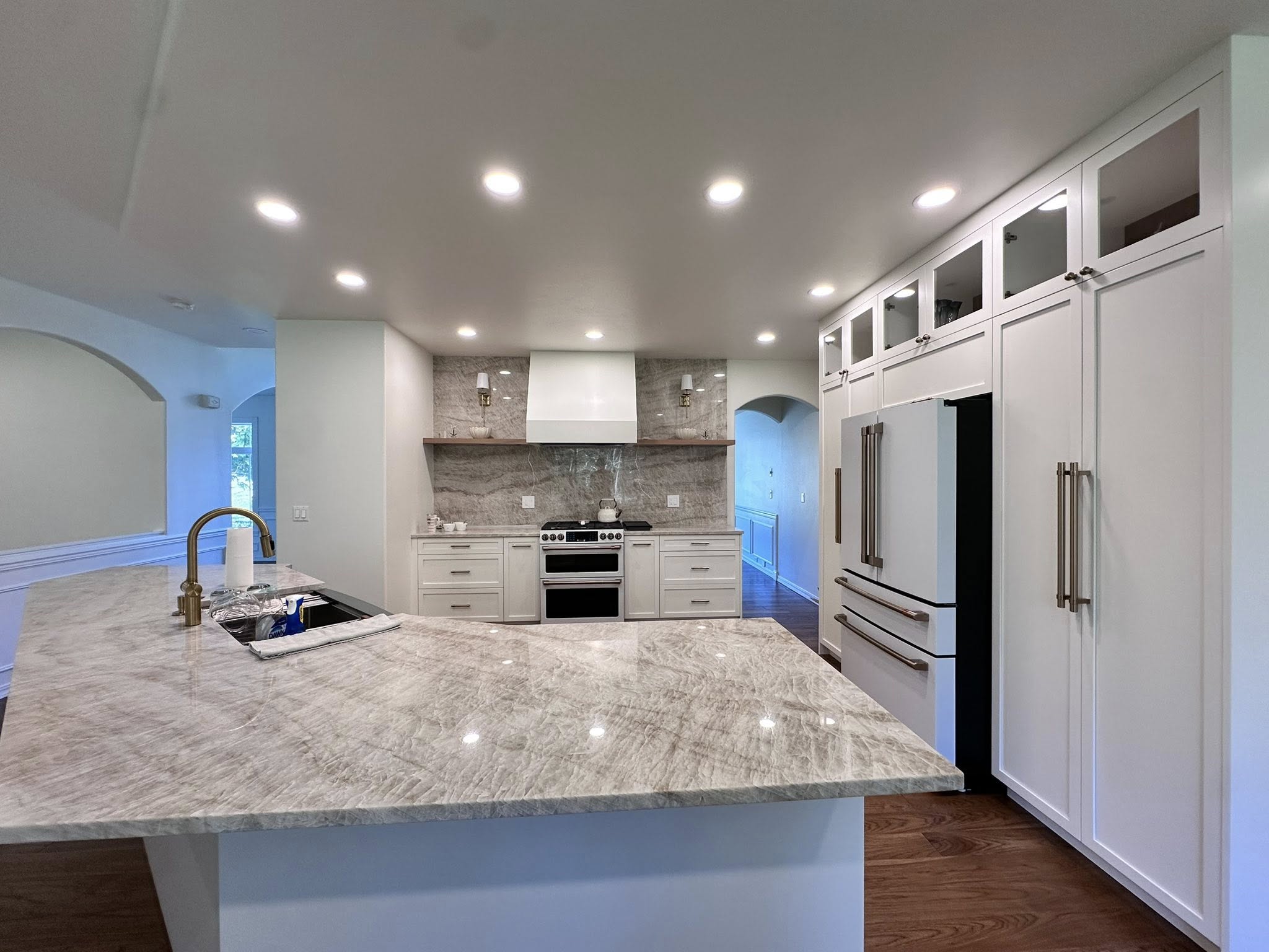 Large stone island and full-height white cabinetry