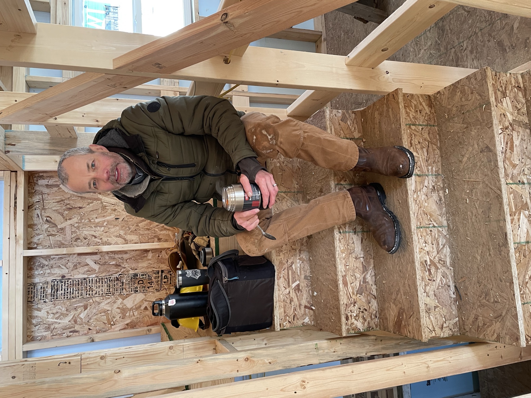 Christian seated on the stairs inside a home during the GRCC builders course